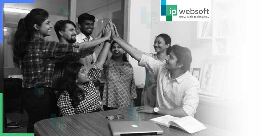 A diverse group of professionals in an office setting with a sign that reads "we are the best software company in India."